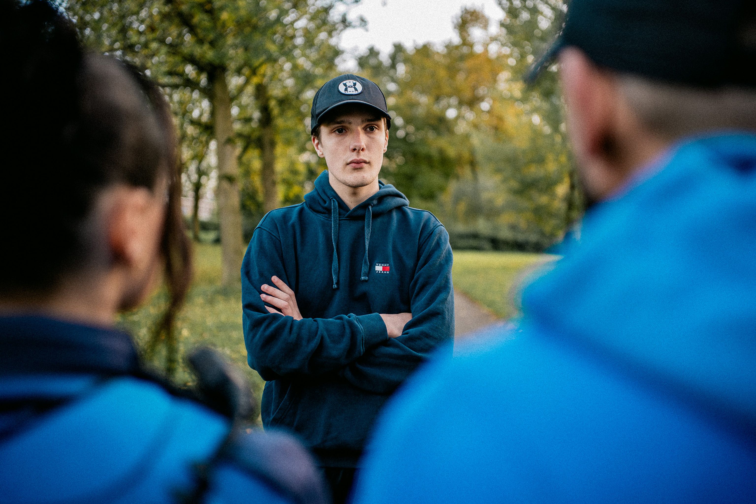 Jongere in gesprek met Jongerenwerker en jeugdboa in een parkje